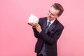 Love for pets. Portrait of pleased happy man looking at white rabbit on his palm and smiling, admiring cute pet. indoor studio Royalty Free Stock Photo