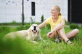 Love for pets - a young blonde woman resting with her dog on the grass Royalty Free Stock Photo