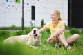 Love for pets - a young blonde woman resting with her dog on the grass Royalty Free Stock Photo