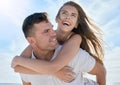 Love, piggyback and happy couple at the beach on vacation while bonding together in Australia. Happiness, care and young Royalty Free Stock Photo