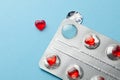 Love pills. Blister pack with red heart shaped pills. Tablets for lovers or potency. Blue background Royalty Free Stock Photo