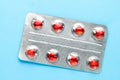 Love pills. Blister pack with red heart shaped pills. Tablets for lovers or potency. Blue background Royalty Free Stock Photo