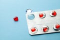 Love pills. Blister pack with red heart shaped pills. Tablets for lovers or potency. Blue background Royalty Free Stock Photo