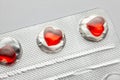 Love pills. Blister pack with red heart shaped pills. Tablets for lovers or potency. Gray background Royalty Free Stock Photo