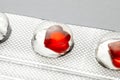 Love pills. Blister pack with red heart shaped pills. Tablets for lovers or potency. Gray background Royalty Free Stock Photo