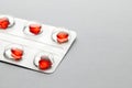 Love pills. Blister pack with red heart shaped pills. Tablets for lovers or potency. Gray background. Copy space for text Royalty Free Stock Photo