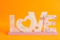 Love in pink letters isolated on an orange background