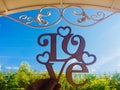 Love plate on the background of a clear sky under a forged roof Royalty Free Stock Photo