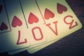 Love, poker playing cards with heart symbol that form the written love