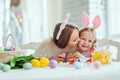 We love preparing for Easter.Mom and daughter are preparing for Easter together.On the table is a basket with Easter eggs, flowers Royalty Free Stock Photo