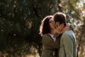 Love, relationship, family and people concept - smiling couple kissing in autumn park