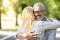 Love And Relationship. Handsome Mature Man Embracing His Wife In Park