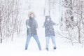 Love, relationship, season and friendship concept - man and woman having fun and playing with snow in winter forest Royalty Free Stock Photo