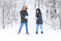 Love, relationship, season and friendship concept - man and woman having fun and playing with snow in winter forest Royalty Free Stock Photo