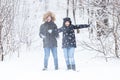 Love, relationship, season and friendship concept - man and woman having fun and playing with snow in winter forest Royalty Free Stock Photo