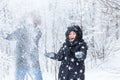 Love, relationship, season and friendship concept - man and woman having fun and playing with snow in winter forest Royalty Free Stock Photo