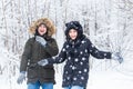 Love, relationship, season and friendship concept - man and woman having fun and playing with snow in winter forest Royalty Free Stock Photo