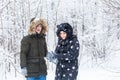 Love, relationship, season and friendship concept - man and woman having fun and playing with snow in winter forest Royalty Free Stock Photo