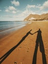 Love and relationship with shadow of a couple holding hands at the beach in summer holiday vacation tourist concept lifestyle. Royalty Free Stock Photo
