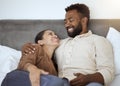 Love, relax and couple in bed in their home, resting and smiling while talking and bonding in bedroom together. Black Royalty Free Stock Photo