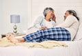 Love, relax and an old couple in bed together, bonding in the morning while enjoying retirement in their home. Happy Royalty Free Stock Photo