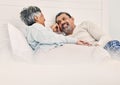 Love, relax and a senior couple in bed together, bonding in the morning while enjoying retirement in their home. Happy Royalty Free Stock Photo