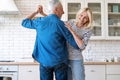 Husband and wife listening music, dancing and enjoying moment in kitchen Royalty Free Stock Photo