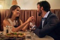 Love, restaurant and couple holding hands at table on valentines day food date with smile, pizza and wine. Date night