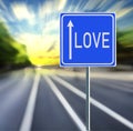 Love Road Sign on a Speedy Background with Sunset. Royalty Free Stock Photo