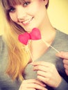 Smiling girl holding hearts.