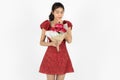 Love and romance on Valentines day. Attractive young Asian woman in red dress holding bouquet of roses over white isolated Royalty Free Stock Photo