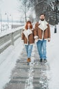 Love romantic couple lovestory. Brutal bearded man, bright red-haired girl woman in winter park. Romantic date, kissing Royalty Free Stock Photo