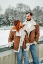 Love romantic couple lovestory. Brutal bearded man, bright red-haired girl woman in winter park. Romantic date, kissing Royalty Free Stock Photo