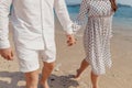 Love - romantic couple in a white clothes holding hands on beach in sunset. Royalty Free Stock Photo