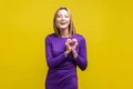 Love, romantic feelings. Portrait of cheerful young woman showing heart symbol. isolated on yellow background Royalty Free Stock Photo