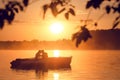 Love and romantic golden river sunset. Silhouette of couple on boat backlit by sunlight Royalty Free Stock Photo