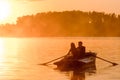 Love and romantic golden river sunset. Silhouette of couple on boat backlit by sunlight Royalty Free Stock Photo