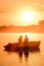 Love and romantic golden river sunset. Silhouette of couple on boat backlit by sunlight Royalty Free Stock Photo