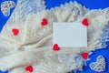 Love scene with white shawl, rattan and felt red hearts, paper card note on blue background. Valentine concept. Flat lay style Royalty Free Stock Photo