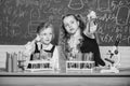 We love science. School children performing experiment in science classroom. Little girls scientists holding test tubes