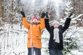 Love, season, friendship and people concept - happy young man and woman having fun and playing with snow in winter forest Royalty Free Stock Photo