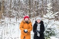 Love, season, friendship and people concept - happy young man and woman having fun and playing with snow in winter Royalty Free Stock Photo