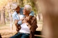 Love, senior couple and hug in park on bench, bonding and romantic together outdoor. Romance, mature man and elderly Royalty Free Stock Photo