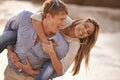 Love sets you free. a happy young couple enjoying a piggyback ride on the beach at sunset. Royalty Free Stock Photo