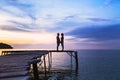 Love, silhouette of affectionate couple on the pier at sunset beach Royalty Free Stock Photo