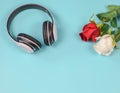 Love songs concept , headphons with red and white roses on blue background