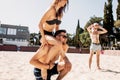 Handsome young man giving piggyback ride to his girlfriend on summer beach Royalty Free Stock Photo