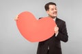 Love, st. valentine`s concept. Businessman holding big heart, toothy smile Royalty Free Stock Photo