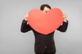 Love, st. valentine`s concept. Businessman holding big heart, worry, panic