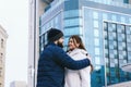 Love story of couple walking in city. Young business man in a blue jacket with a beard. And a cute woman in long coat Royalty Free Stock Photo